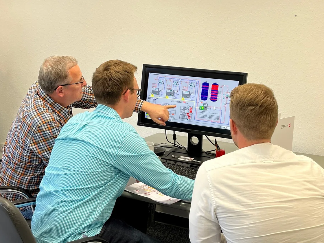 Mitarbeiter der GA GmbH besprechen am Bildschirm ein Anlagenbild im Gebäudeleitsystem GA-Leit